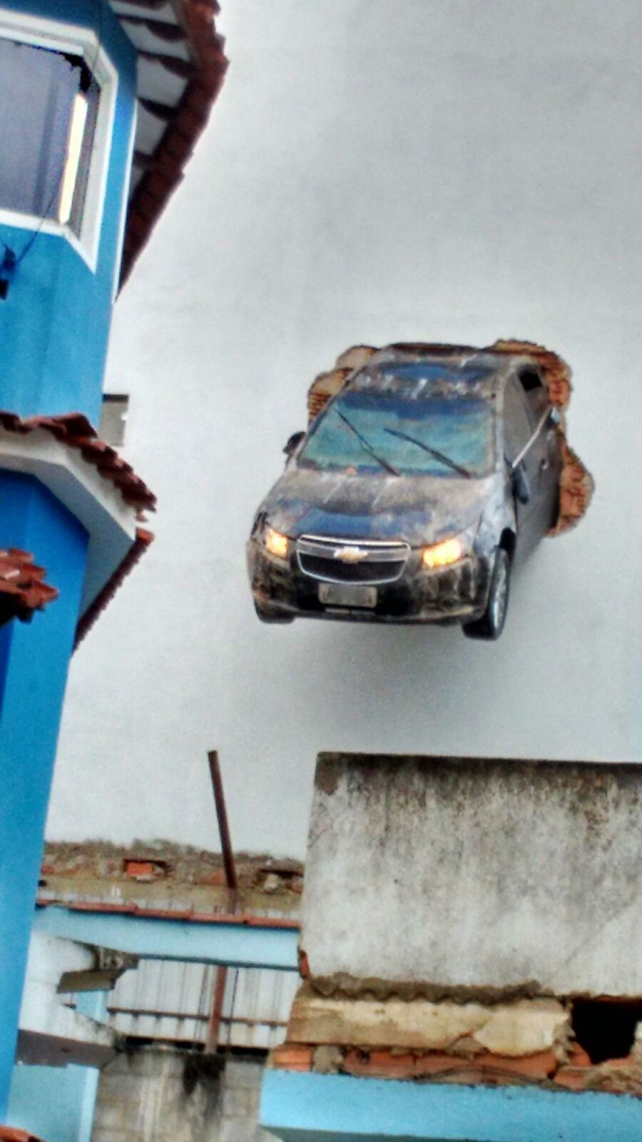 Motorista acelera em garagem e carro fica pendurado em Colatina, espírito santo (Foto: Divulgação/Polícia Militar)
