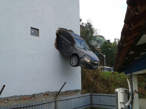 Carro ficou pendurado em Colatina, no Noroeste do Espírito Santo, após homem acelerar na garagem (Foto: Divulgação/Polícia Militar e Corpo de Bombeiros)