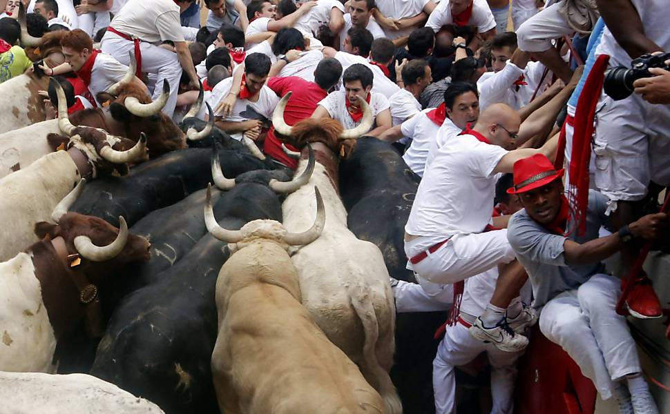 Participantes ficam encurralados por touros durante o sétimo dia da tradicional festa de São Firmino, em Pamplona (Espanha)