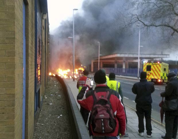 Fumaça e fogo se erguem do local do acidente com helicóptero nesta quarta-feira (16) em Londres (Foto: Toby Scott, PA/AP)