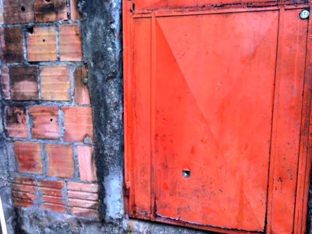 Marcas de tiros ficaram em porta de casa na Rua 7 de Setembro (Foto: Adneison Severiano/G1 AM)