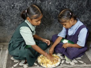 Meninas fazem refeição na escola na cidade de Hyderabad, na Índia. Programa indiano oferece refeições a 120 milhões de crianças nas escolas