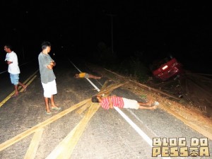 Curiosos observam as pessoas caídas na BR. Uma morreu