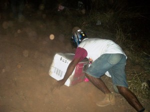 Homem com capacete foge levando um aparelho do caminhão acidentado