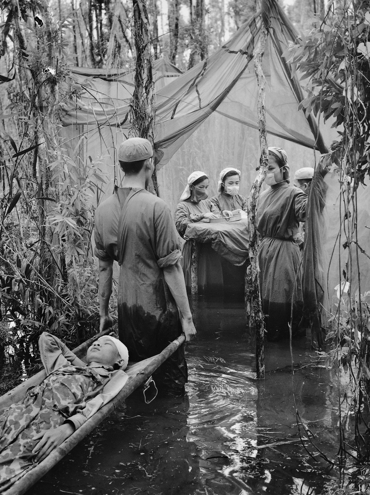 1970 - Uma criança cambojana atingida por destroços de bombas é socorrida em um hospital improvisado em meio ao manguezal. Em respeito ao garoto, o fotógrafo decidiu não vender ou imprimir esta foto (Foto: Divulgação)