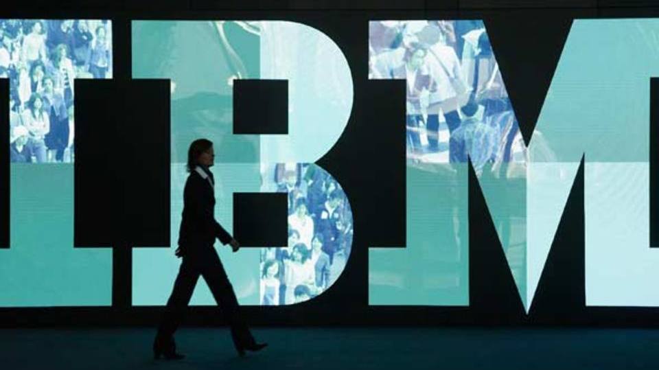 Mulher passa em frente a letreiro da IBM