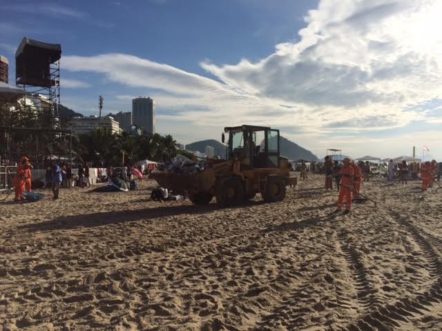 Garis usavam retroescavadeira para retirar lixo deixado durante o réveillon (Foto: Alba Valéria Mendonça/G1)