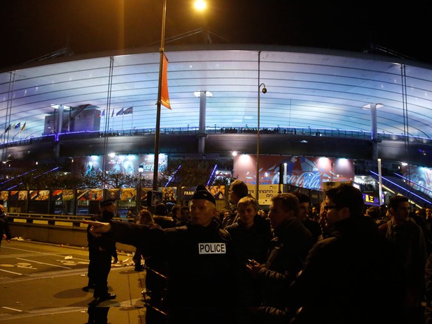 Policiais orientam as pessoas em frente ao Stade de France após ataque (Foto: Michel Euler/AP)