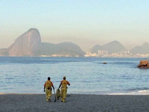 Funcionários limpar as areias da Praia de Icaraí, em Niterói (Foto: Matheus Rodrigues/G1)