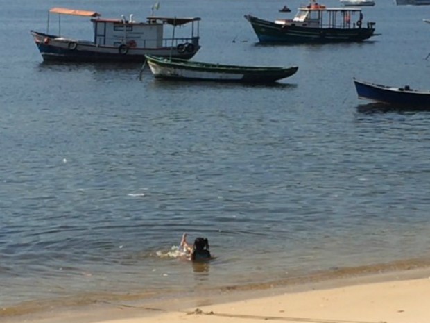 Criança brincava na Praia de Jurujuba, em Niterói, em mar com lixo (Foto: Matheus Rodrigues/ G1)