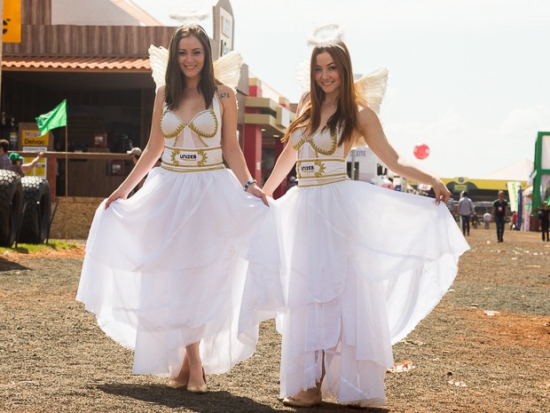 De vestido branco, asas e auréola, Talita e Aline caminham pela feira em Ribeirão Preto, SP (Foto: Érico Andrade/G1)