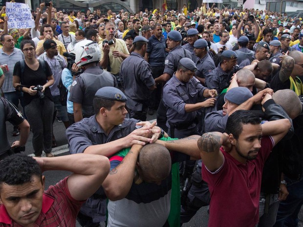 Policiais militares prendem integrantes do grupo 'Carecas do Subúrbio' durante protesto na Avenida Paulista, em São Paulo. Artefatos como fogos de artifício e soco inglês foram apreendidas com alguns deles (Foto: Leonardo Benassatto/Futura Press/Estadão Conteúdo)