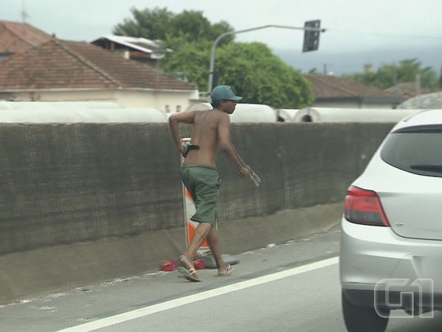 Assaltante anda pela rodovia dos Imigrantes armado (Foto: Reprodução/G1)