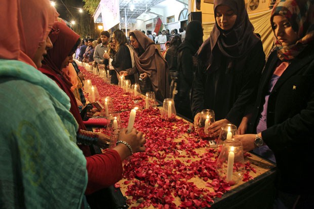 Apoiadores do movimento Mutahida Qaumi seguram velas em Karachi em  vigília pelas vítimas do massacre (Foto: AP Photo/Fareed Khan)