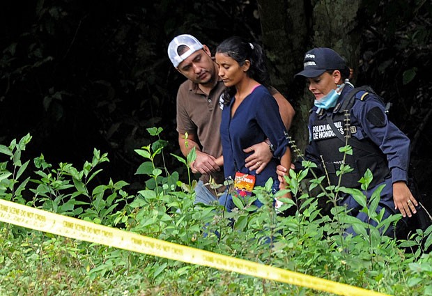 Irmã de María José Alvarado e Sofia Trinidad é amparada por policiais depois de reconhecer os corpos das famliliares (Foto: Orlando Sierra/AFP)