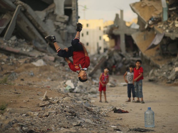 Jovem brinca de 'parkour' em ruína de bairro devastado da Cidade de Gaza (Foto: Mohammed Salem/Reuters)