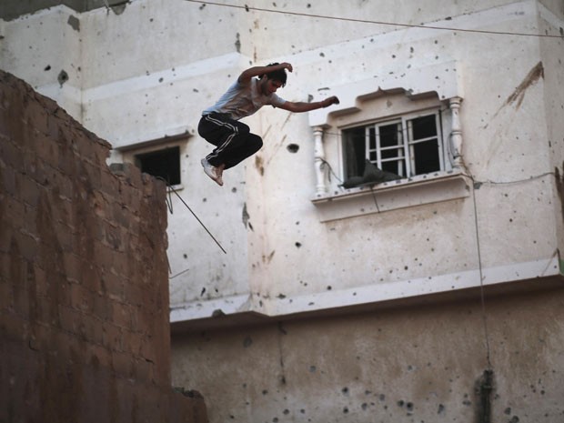 Jovem salta de muro durante corrida de parkour em Gaza (Foto: Mohammed Salem/Reuters)