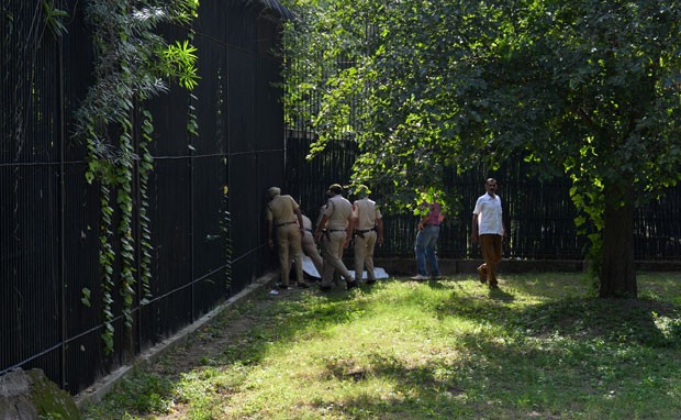 Policiais cercam o corpo do estudante que foi morto por um tigre após entrar em sua jaula no zoológico de Nova Déli (Foto: Chandan Khanna/AFP)