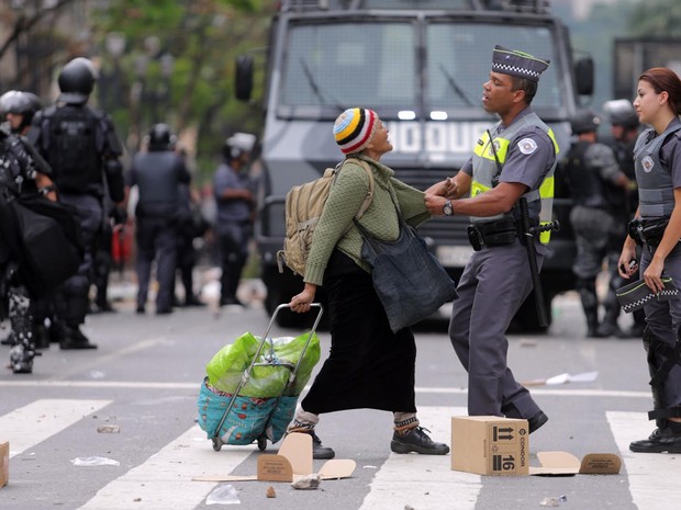 Policial puxa pela roupa uma das sem-teto que ocupavam o antigo prédio do Hotel Aquarius, no centro de São Paulo (Foto: Nilton Fukuda/Estadão Conteúdo)