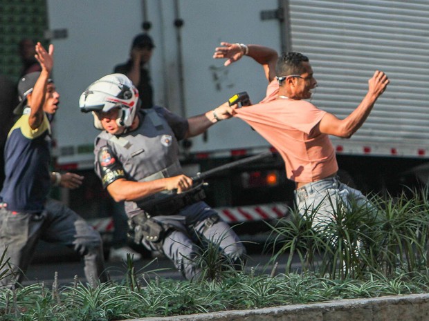 Policial tenta deter homem se envolveu em confronto durante reintegração de posse na Avenida São João, Centro de São Paulo (Foto: Marco Ambrosio/Estadão Conteúdo)