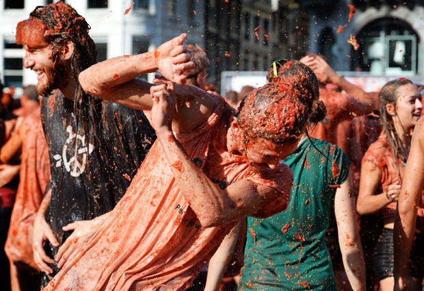 Jovem tenta se proteger durante 'guerra de tomates' em Amsterdã, na Holanda (Foto: Piroschka van de Wouw, ANP/AFP)