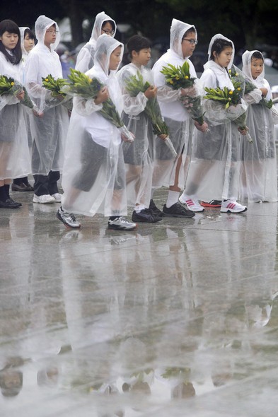 A cerimônia foi realizada sob uma fina garoa. Com capas de chuva, crianças depositaram flores no Memorial da Paz de Hiroshima, em lembrança às vítimas