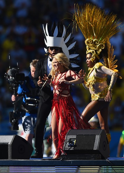 Shakira com seu rebolado característico. Carlinhos com seus figurinos extravagantes.