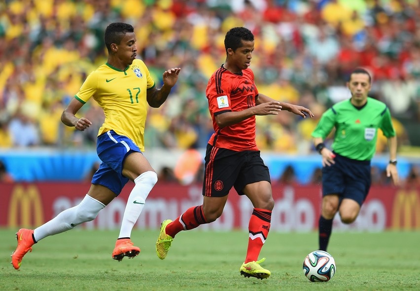 O brasileiro Luiz Gustavo corre atrás do mexicano Giovani dos Santos (e da bola!)