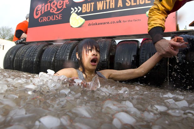 Participante da corrida de resitência Tough Mudder, em Londres, pula em piscina com gelo (Foto: Justin Tallis/AFP)