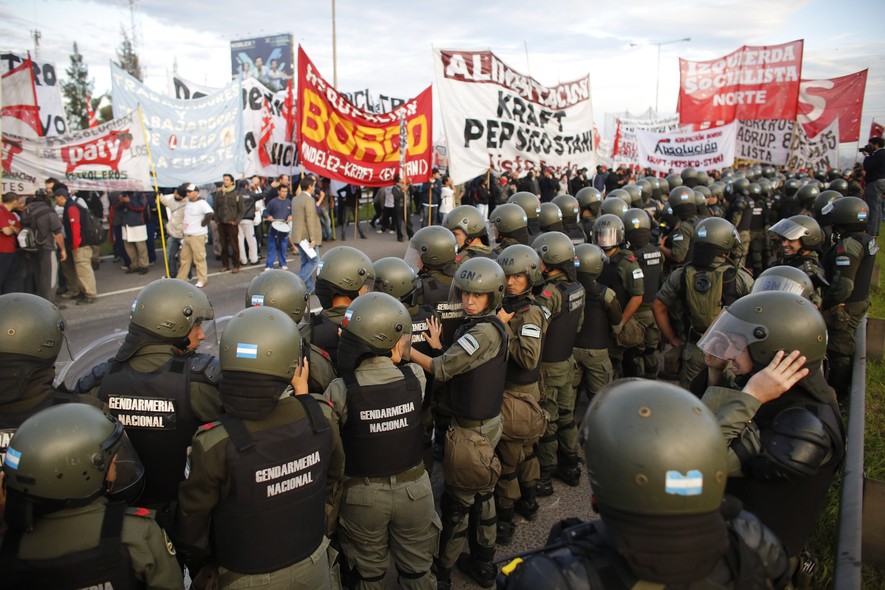 Policiais diante de manifestantes que bloquearam a rodovia Panamericana, via de acesso a Buenos Aires