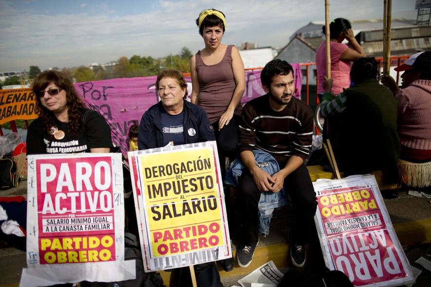 Manifestantes bloqueiam acesso de rodovia em Buenos Aires. Nos cartazes, queixas sobre salários e impostos