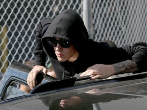 Justin Bieber sai do carro para acenar para fãs e jornalistas (Foto: Joe Raedle/Getty Images/AFP)