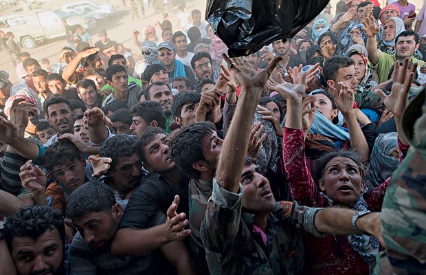 RESISTÊNCIA Sírios recebem comida no campo de Kawergost, no Iraque. Metade dos refugiados é formada por crianças (Foto: Lynsey Addario/The New York Times)