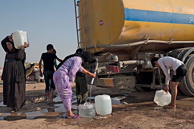 Mulheres e crianças retiram água distribuída pela ONU (Foto: Lynsey Addario/The New York Times)