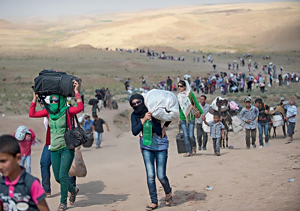 3. Sírios cruzam a fronteira com o Iraque, rumo aos campos de refugiados ao norte do país vizinho (Foto: Lynsey Addario/The New York Times)