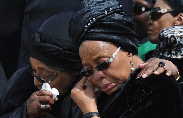  A ex-mulher de Nelson Mandela, Winnie Mandela (à esq.) e sua viúva, Graça Macel, choram juntas durante cortejo fúnebre (Foto: AP Photo/Kopano_Tlape, CGIS)