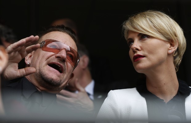 O cantor e líder da banda U2, Bono, a atriz sul-africana Charlize Theron participam do tributo ecumênico em homenagem a Nelson Mandela, realizado na manhã desta nesta terça-feira (10) (Foto: AP Photo/Ben Curtis)