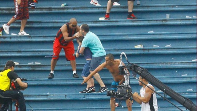 Segurando o filho, Marco Aurélio ainda conversa e pega na mão de um dos torcedores do Atlético-PR