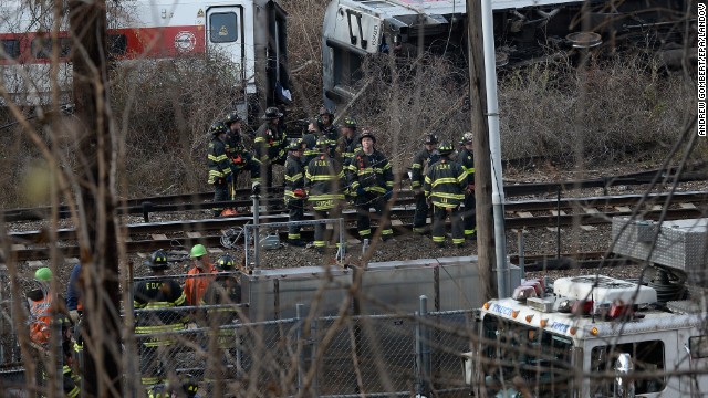 Bombeiros e equipes de resgate trabalham no local do descarrilamento do comboio de passageiros perto da estação Spuyten Duyvil. 