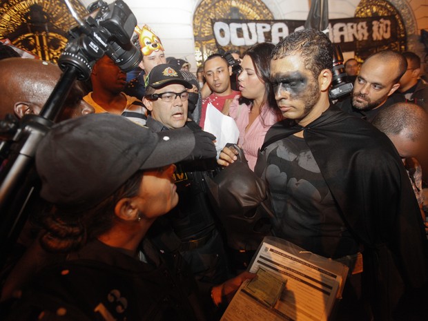 Batman mascarado mostra a cara e documento em manifestação no Centro do Rio (Foto: Bruno Poppe /  Estadão Conteúdo)