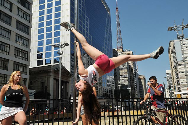 Jovem faz pole dance na avenida Paulista, no centro de São Paulo, para divulgar o 5º Campeonato de Pole Dance Brasileiro