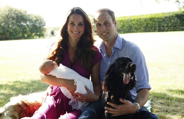 Imagem datada do começo de agosto mostra o príncipe William, a duqesa de Cambridge e o bebê George. Aparecem também na foto os cães Tilly (golden, à esquerda) e Lupo. A foto foi tirada pelo pai de Kate, no jardim da residência oficial da família Middleton    (Foto: AFP)