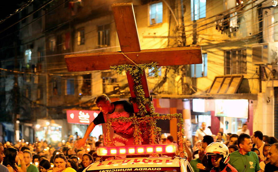 A cruz peregrina, símbolo da Jornada Mundial da Juventude, é levada pelas ruas da favela da Rocinha, no Rio de Janeiro, nesta quinta-feira (18)