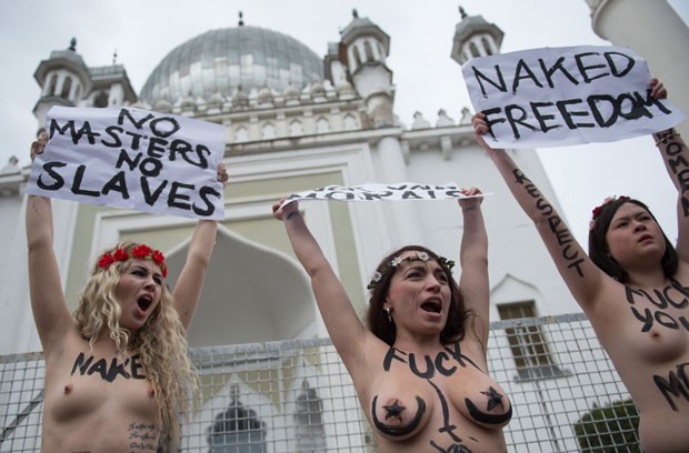 Jovens mostram os seios em protesto em frente a mesquita de Berlim, na Alemanha (Foto: Johannes Eisele/AFP)