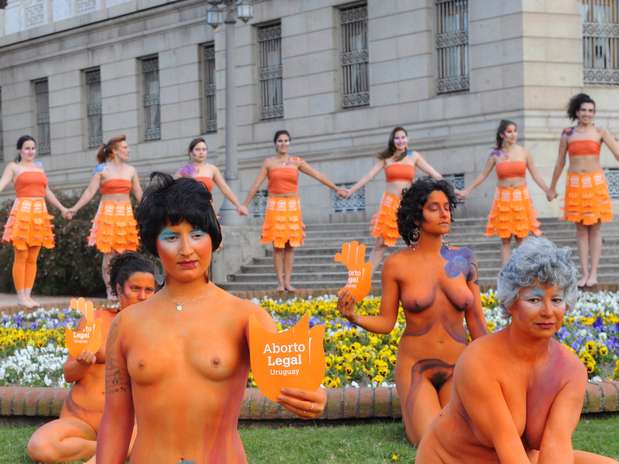 Um grupo de 20 mulheres uruguaias se manifestou na frente do Parlamento uruguaio, algumas delas completamente nuas e com seu corpo coberto apenas com uma pintura laranja, em protesto pelas deficiências do projeto debatido nesta terça-feira por legisladores que busca descriminalizar o aborto  Foto: AFP