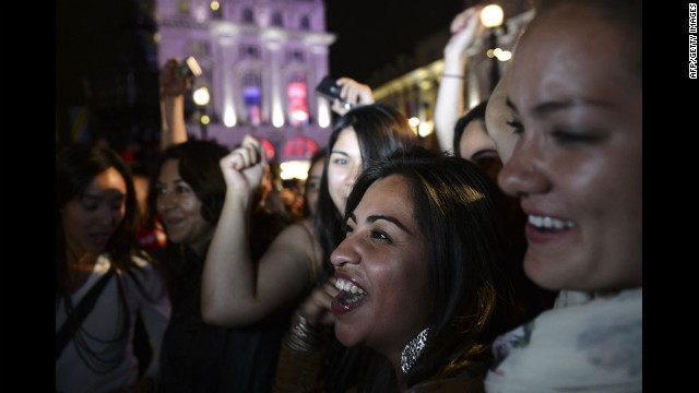 Pessoas torcer como eles vêem a cerimônia de abertura dos Jogos Olímpicos de Londres 2012 em uma tela ao ar livre em Piccadilly Circus.