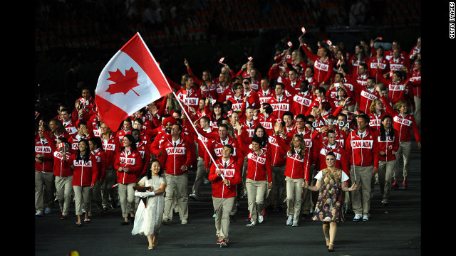 Simon Whitfield da equipa de triatlo olímpico Canadá carrega a bandeira de seu país.