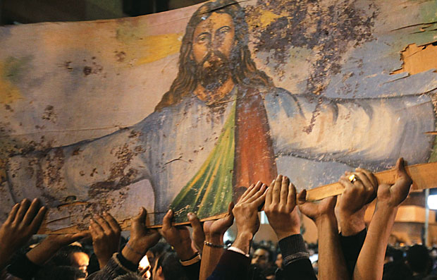 SANGUE DERRAMADO Cristãos coptas, do Egito, carregam uma imagem de Jesus Cristo manchada de sangue, em ato contra a violência de extremistas islâmicos  (Foto: Asmaa Waguih/Reuters)