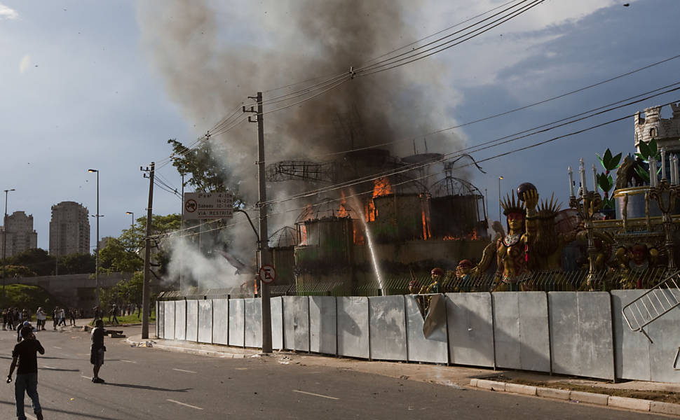 Carro alegórico da Pérola Negra pega fogo após ser incendiado por um integrante da Gaviões Leia mais