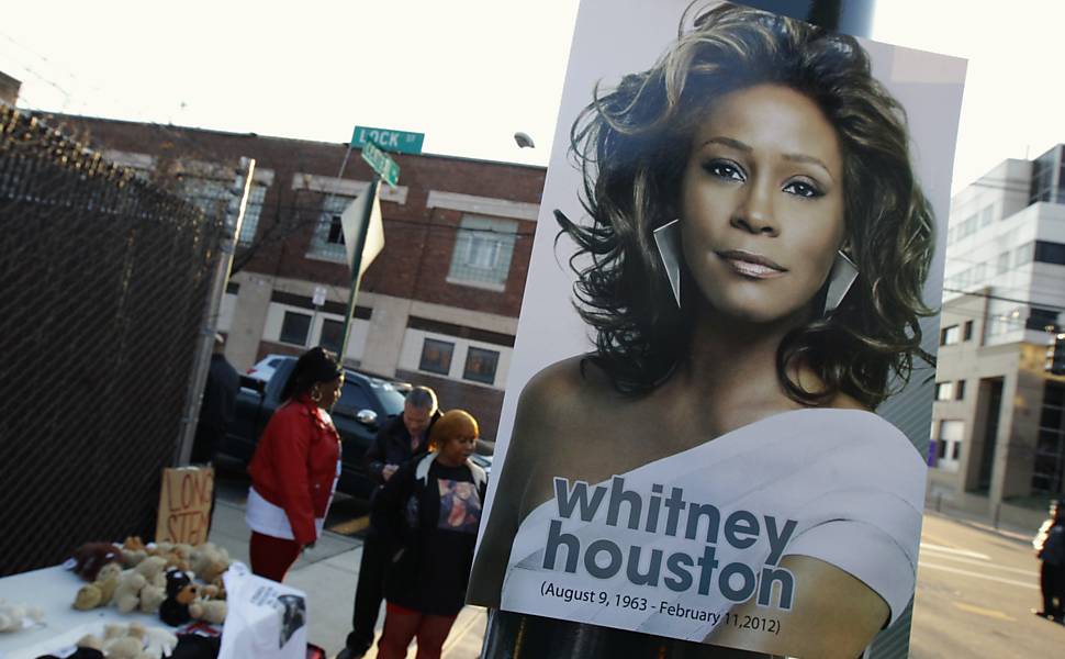 Pôster com imagem de Whitney Houston é pendurado em poste nas proximidades da igreja onde acontece o funeral da cantora